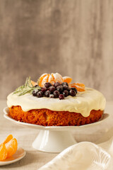 Christmas cake with tangerines, cranberry and rosemary on a stand 