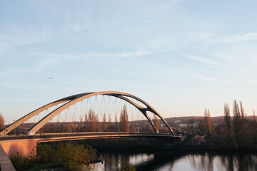 Fototapeta na wymiar Frankfurt Osthafenbrücke, blue sky and a plane in the background.