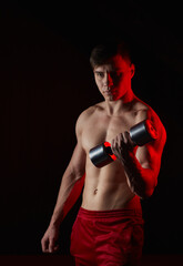 Fototapeta na wymiar Muscular athlete man exercise on a black background