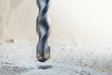 metal drill bit make holes in concrete wall on industrial drilling machine with shavings. Metal...