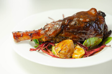 Delicious Lamb shank with red wine and rosemary gravy served on the mixed leaf salad