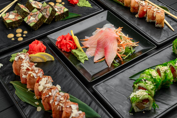 Fresh and delicious sushi set on black background