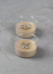 Vegan dessert, Panna Cotta cream sunflower paste with seeds in a glass Cup on a light background