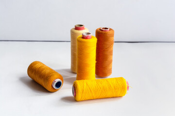 Five sewing thread spools on isolated white background.