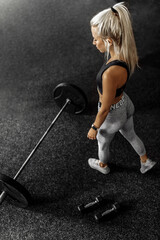 fitness woman trains with heavy weights in the gym, Sportswoman lifts the barbell in the gym.
