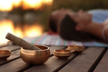 Couple at healing session outdoors, focus on singing bowl