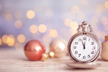 Fototapeta na wymiar Pocket watch and festive decor on table against blurred lights, space for text. New Year countdown