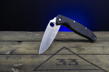 Knife with a black handle and a hole in the blade. The knife is in a semi-folded position.