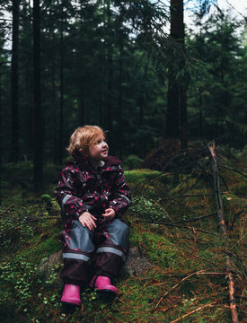 Toddler girl sitting in forest