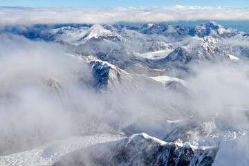 Fototapeta na wymiar Above the mountains and clouds. View from the slope of Marble Wall Peak, Central Tian Shan, Kazakhstan - China.