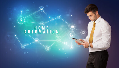 Businessman in front of cloud service icons with HOME AUTOMATION inscription, modern technology concept