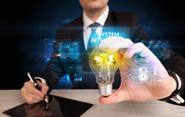 Businessman holding lightbulb with SYSTEM INTEGRATION inscription, online security idea concept