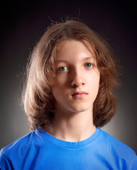 Portrait of a Boy with Long Hair in Blue Top. - 398764283