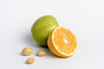 sliced lemon, green apple and peanuts on white background