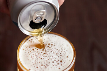 Canned beer puring into mug, light wheat beer
