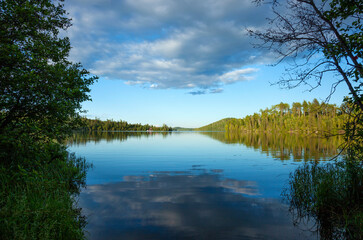 Fototapeta na wymiar Calm blue northern Minnesota lake and tree line on a sunny evening