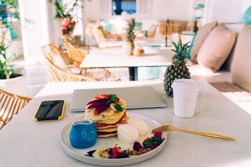 Delicious pancakes with fruits on table
