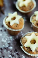 close up of delicious hand-made muffins decorated with a star-shaped pear, sugar and chocolate.