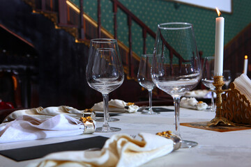 Festive table setting. Christmas or New Year. Candles on the table. Napkin rings. Photo in the interior. Out of focus. Without people.