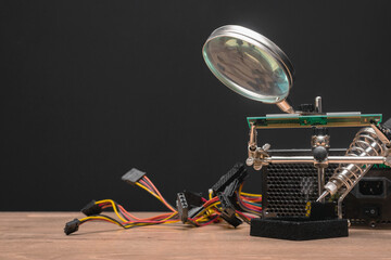 Computer parts and soldering iron on the technician table background.