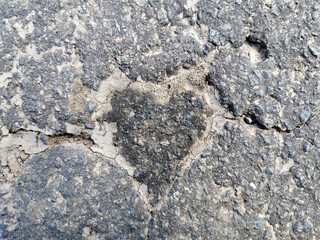 Ein graues Herz im Asphalt