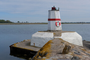 A lighthouse by a small fishing port, on the Swedish south coast