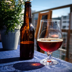 a bottle and a glass of beer on a sunny balcony
