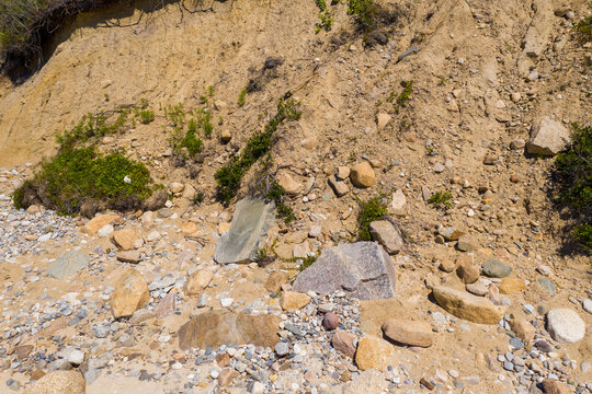 Cliff face of sand cliff with overhanging dirt