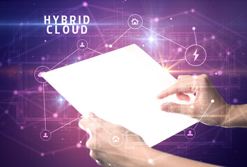 Holding futuristic tablet with HYBRID CLOUD inscription, cyber security concept