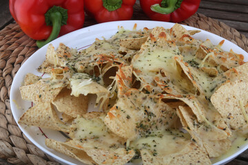triangle nachos with hot cheese sauce as snack mexican food