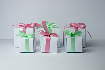 White gifts with pastel mint and pink ribbons. Set of gift box isolated on white background.Christmas gift boxes on white background. Beautiful Christmas background with shiny balls and ribbons.
