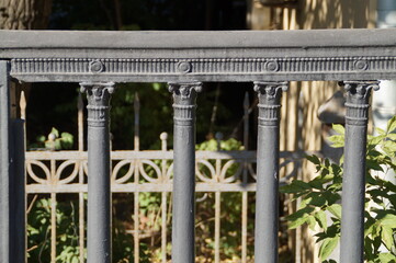 black cast iron fence on a Sunny summer day