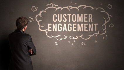 businessman drawing a cloud with CUSTOMER ENGAGEMENT inscription inside, modern business concept