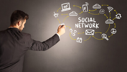 businessman drawing social media icons with SOCIAL NETWORK inscription, new media concept