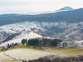 Dark blue forest hills covered with hoarfrost. Early winter freeze weather. Tollenstein Castle...