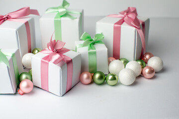 White gifts with pastel mint and pink ribbons. Set of gift box isolated on white background.Christmas gift boxes on white background. Beautiful Christmas background with shiny balls and ribbons.