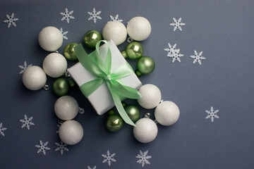White gift with mint ribbons with snowflakes. A gift box isolated on gray background.Christmas gift boxes on gray background. Beautiful Christmas background with shiny balls and ribbons in mint color.