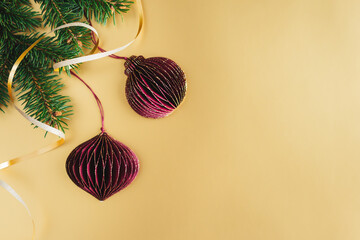 Christmas decorations with a spruce branches on a golden background. Christmas wallpaper or postcard concept.