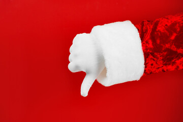 Santa thumb down. Santa Claus gloves says dislike and negative sign.