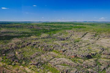 a grassy area with rocks and a body of water in the distance