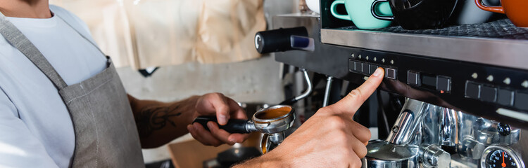 cropped of barista operating coffee machine while holding portafilter, banner