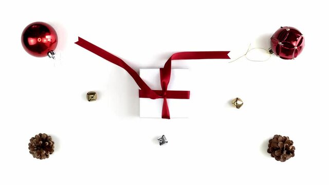 Hand and arm shot of a mixed race African American woman untying a bow on a small white gift box Christmas present wrapped with a red ribbon and bow sitting in middle of festive background.