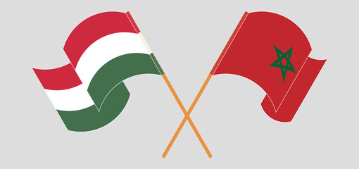 Crossed and waving flags of Hungary and Morocco