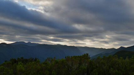 Beautiful panoramic view of the western mountain range of Madeira island, Portugal with mountains covered by dense green vegetation on cloudy day.