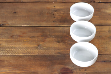 Fototapeta na wymiar white bowl in wooden table