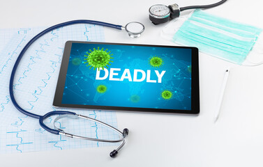 Close-up view of a tablet pc with DEADLY inscription, microbiology concept