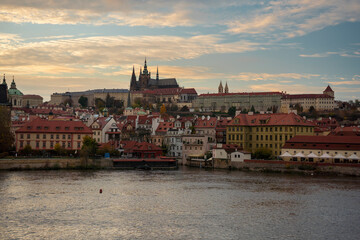 Fototapeta premium old prague castle and charles bridge and st. vita church lights from street lights are reflected on the surface of the vltava river in the center of prague at night in the czech republic