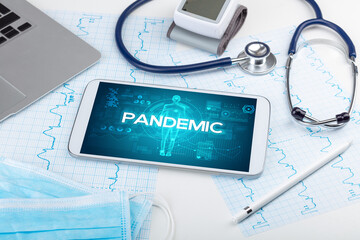 Tablet pc and doctor tools with PANDEMIC inscription, coronavirus concept