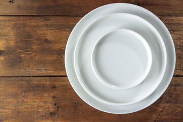 Tableware: white empty plate isolated on the wooden table