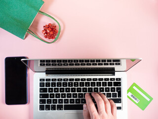 Man hands on laptop on festive pink background